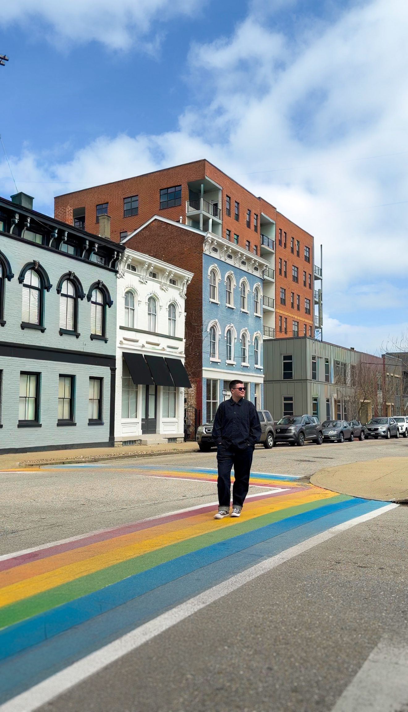 Chase Vondran crosses the street on a crosswalk painted as a pride flag