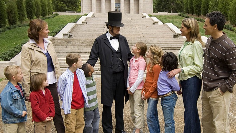 An Abraham Lincoln reenactor stands with a group of children at Abraham Lincoln Birthplace National Historical Park
