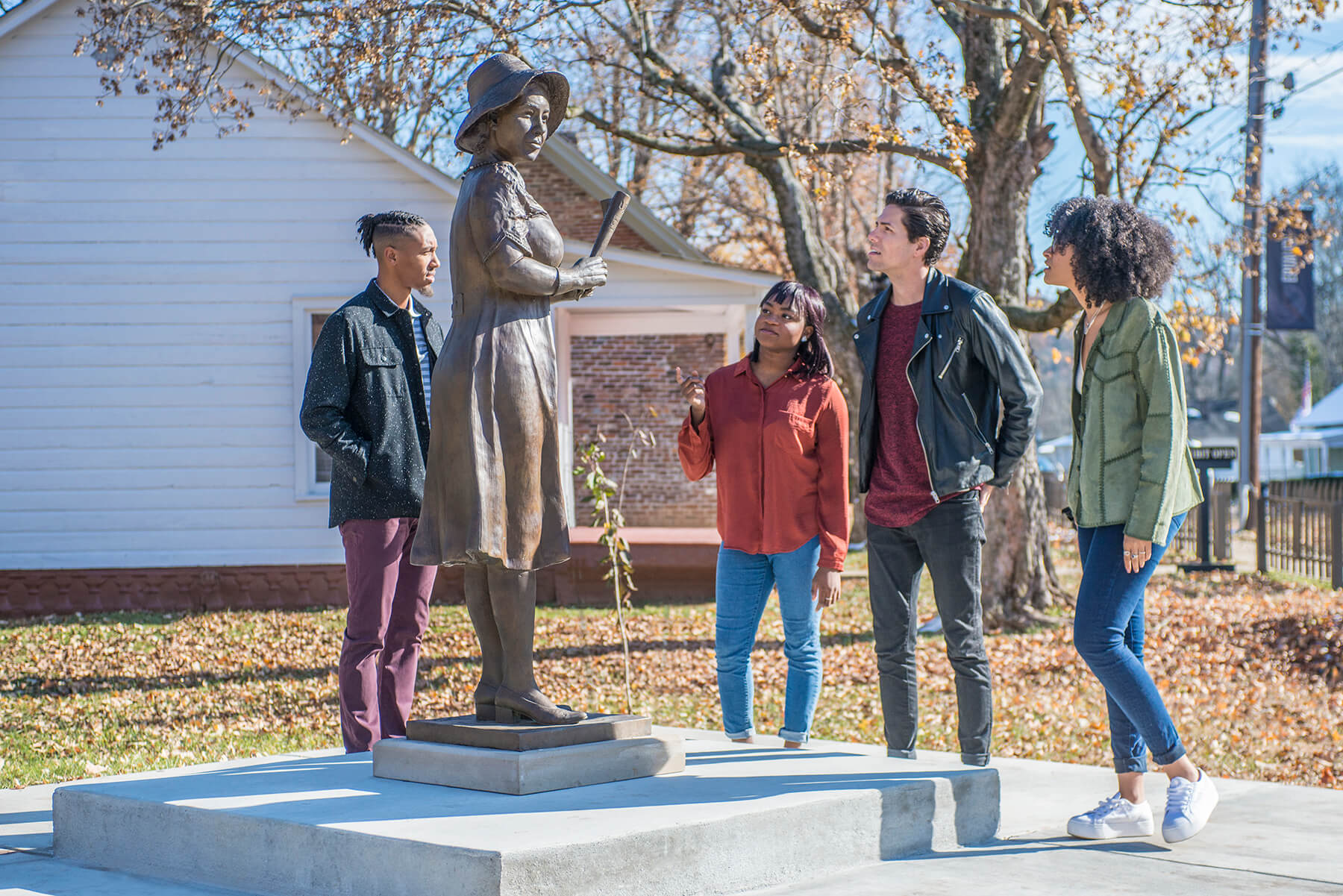 Tour group gathers around a statue at SEEK Museum  on a beautiful fall day. 
